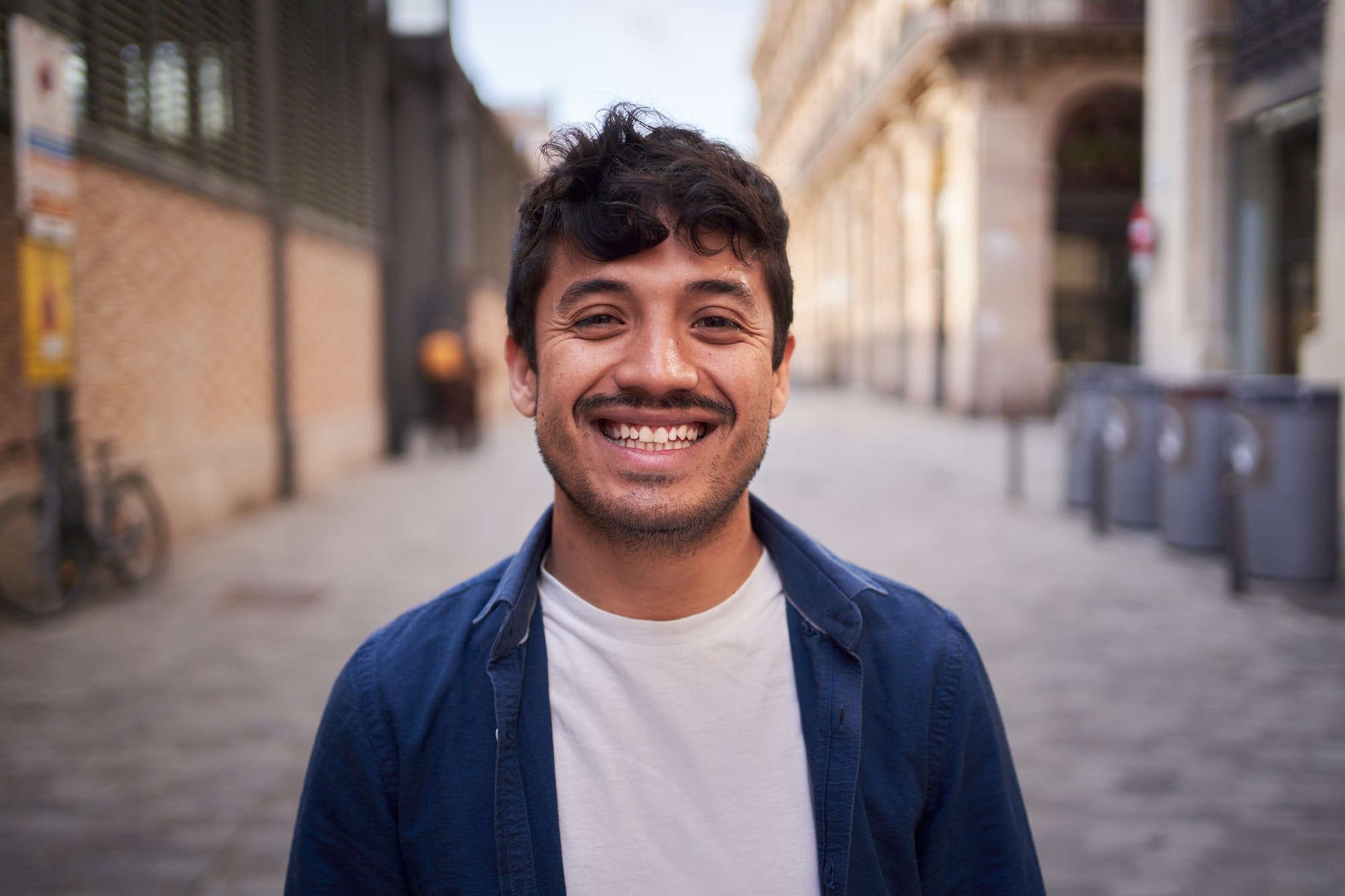 Portrait of happy young Latin man happy smiling face on street. Male people cheerful.